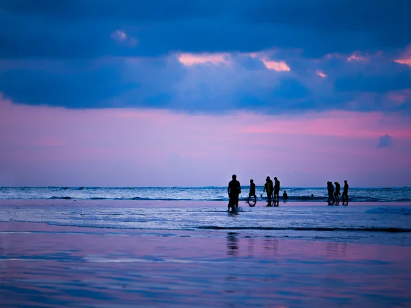 Силуэты людей на закате на пляже Кута Бали I — стоковое фото