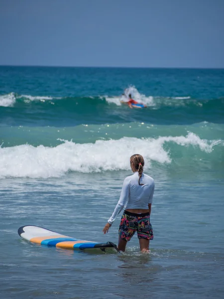 Hermosa joven surfeando en Kuta — Foto de Stock