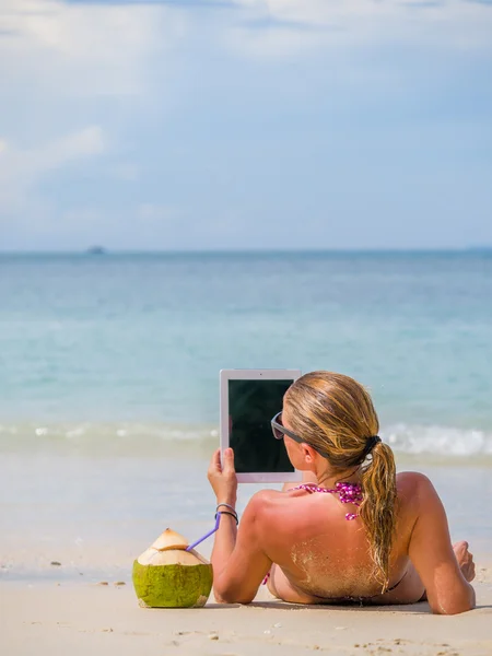 Mujer en la playa en Tailandia usando su tableta — Foto de Stock