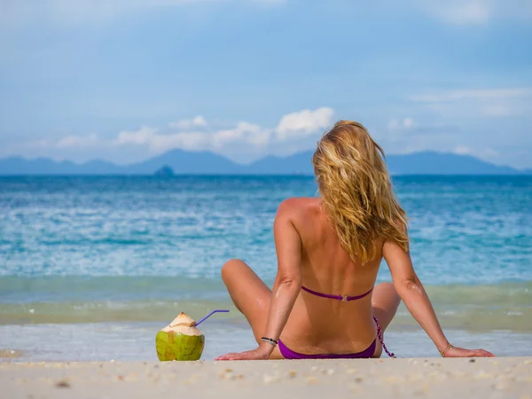 Γυναίκα στην παραλία με καρύδα ποτό — Φωτογραφία Αρχείου