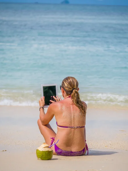 Mujer en la playa en Tailandia usando su tableta — Foto de Stock