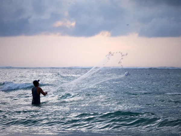 Рыбак на пляже Куты на Бали — стоковое фото