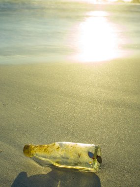 Gün batımında sahilde şişe