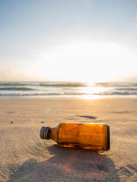 Fles op het strand bij zonsondergang — Stockfoto