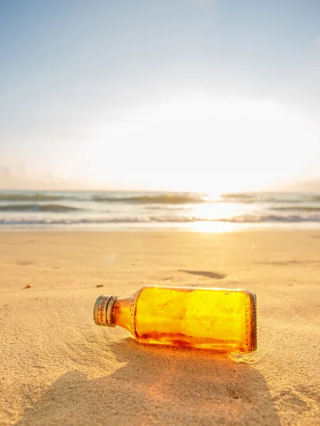 Fles op het strand bij zonsondergang — Stockfoto