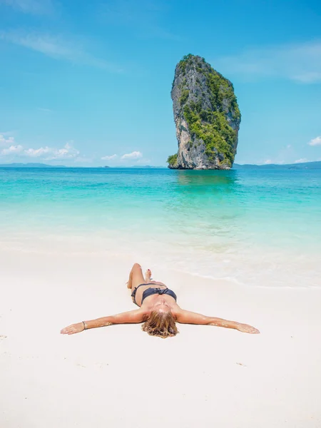 Femme en bikini bronzant sur la plage — Photo