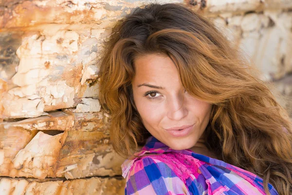 portrait of sexy brunette woman posing at shipwreck