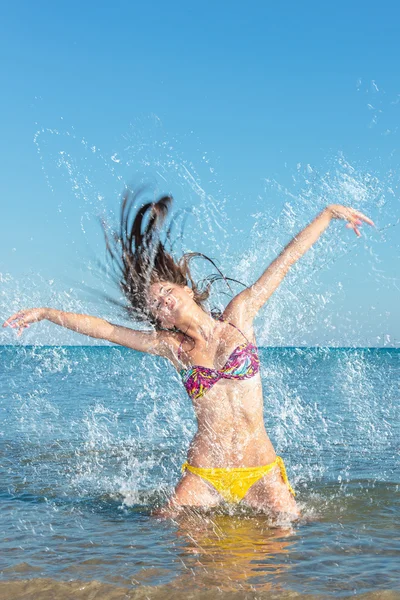 Skönhet modell flicka stänkande vatten i havet — Stockfoto