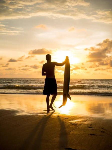 Surfista en la playa del océano al atardecer en la isla de Bali — Foto de Stock