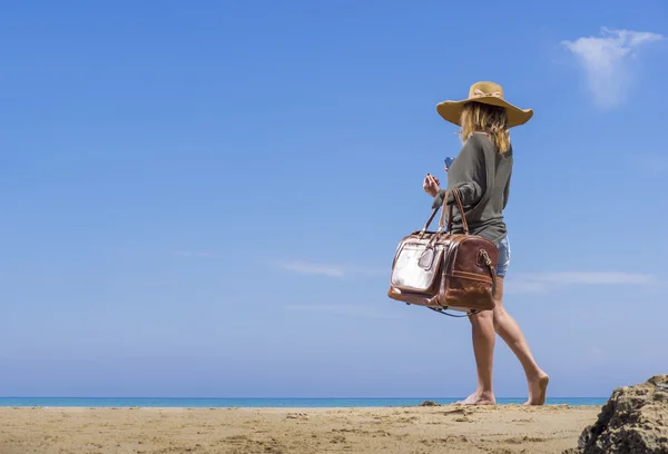 Donna con borsa da viaggio in pelle sulla spiaggia — Foto Stock