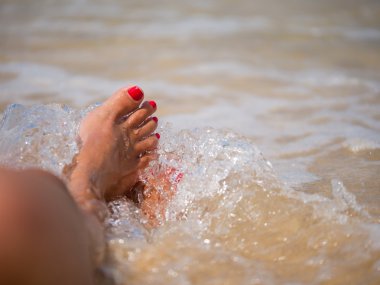 Sahilde kadın ayak üzerinde su sıçrama