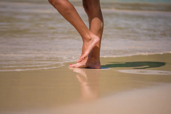 Splash auf weiblichen Beinen am Strand — Stockfoto