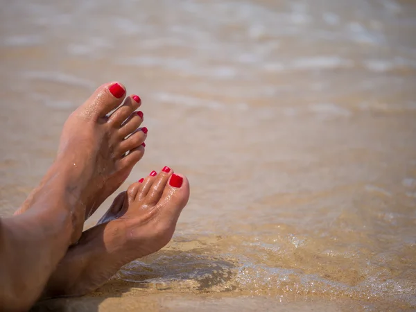 Water splash on female legs on beach — Stock Photo, Image