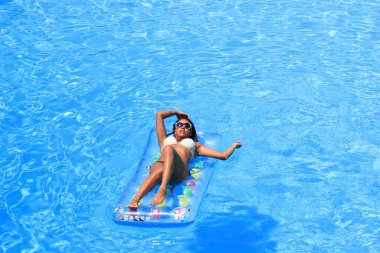 Havuzda dinlenen bir kadın.