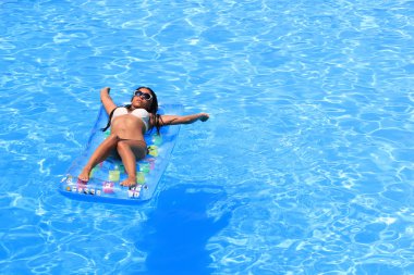 Havuzda dinlenen bir kadın.