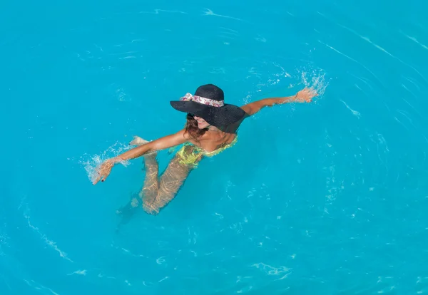 Uma menina está relaxando em uma piscina — Fotografia de Stock