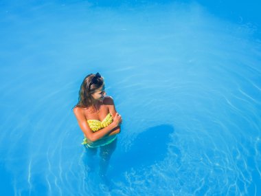 bir kızın rahatlatıcı bir yüzme havuzunda