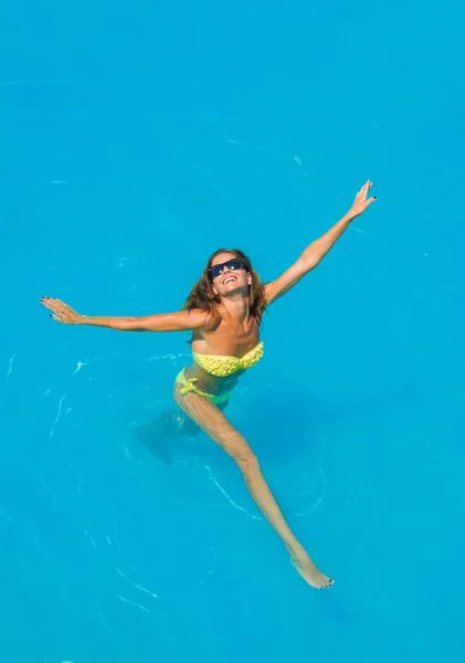 Uma menina está relaxando em uma piscina — Fotografia de Stock