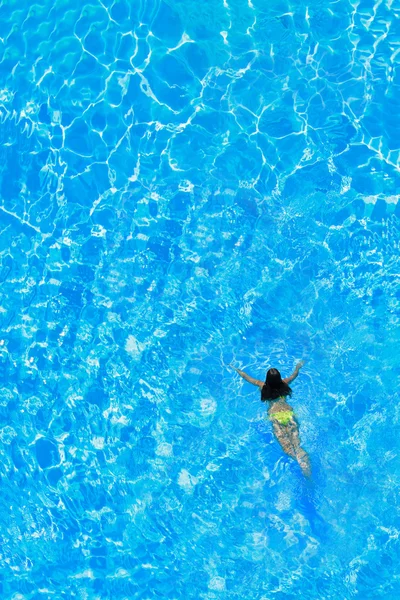 Une fille se relaxe dans une piscine — Photo