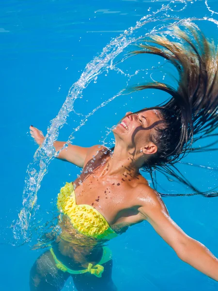 Joven chica bronceada lanzando el pelo mojado de nuevo en la piscina — Foto de Stock