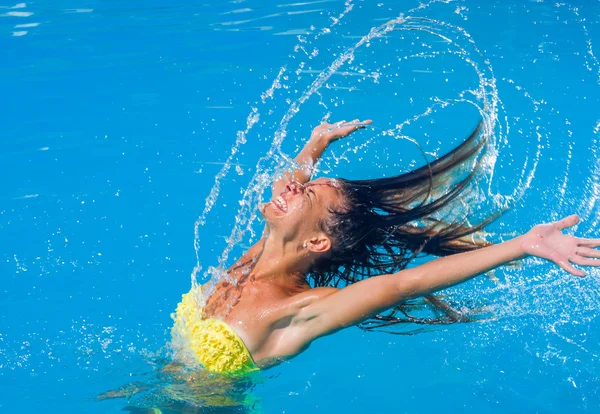 Young tanned girl throwing wet hair back in swimming pool — Stock Photo, Image