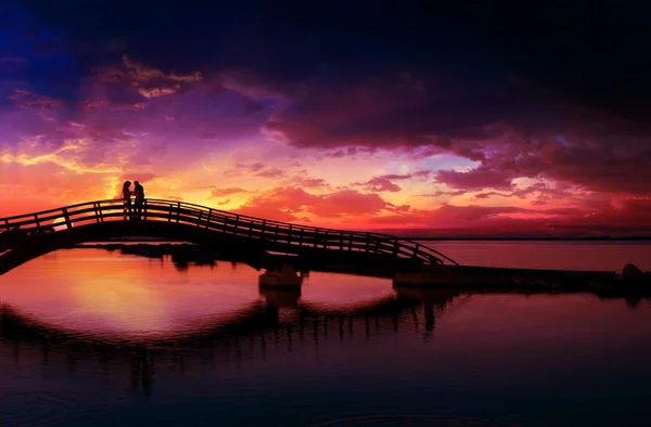 Pár élvezi a romantikus naplementét a Lefkas város híd — Stock Fotó