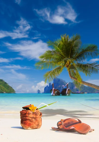 Coconut cocktail with drinking straw and sandals — Stock Photo, Image