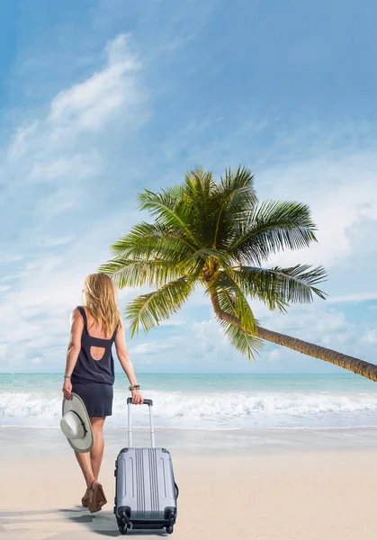 ビーチにスーツケースを着た女性が — ストック写真