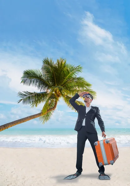 Hombre de traje con una maleta en la playa — Foto de Stock