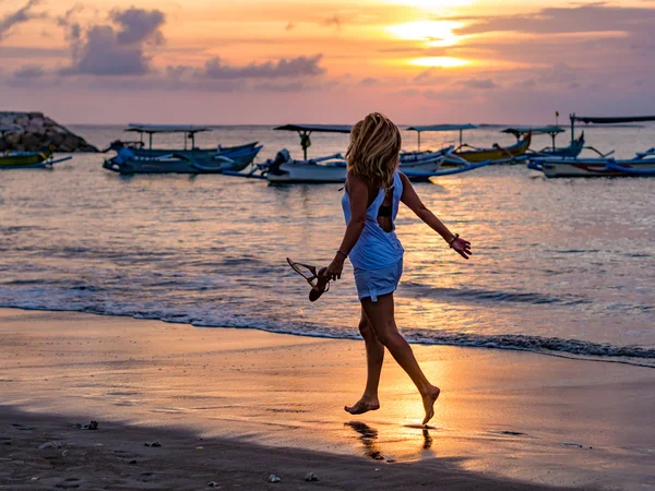 Femme sur la plage à Bali Indonésie tenant ses sandales coucher de soleil — Photo