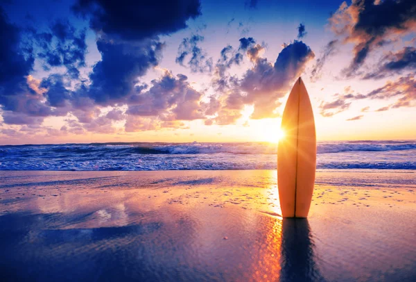 Tabla de surf en la playa al atardecer — Foto de Stock