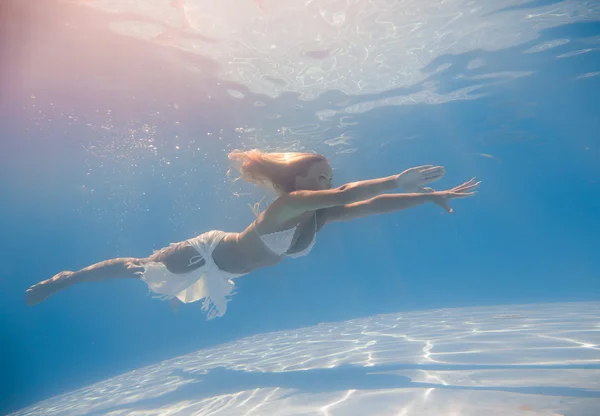 Mujer joven nadando bajo el agua — Foto de Stock