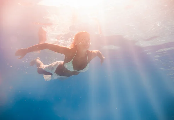 Junge Frau schwimmt unter Wasser — Stockfoto