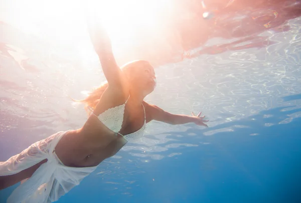 Νεαρή γυναίκα κολυμπά κάτω από το νερό — Φωτογραφία Αρχείου