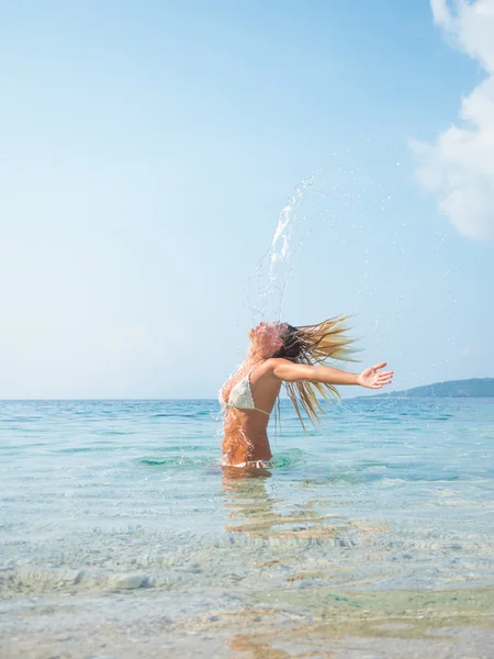 Blonde vrouw in het water haar zwaaien — Stockfoto