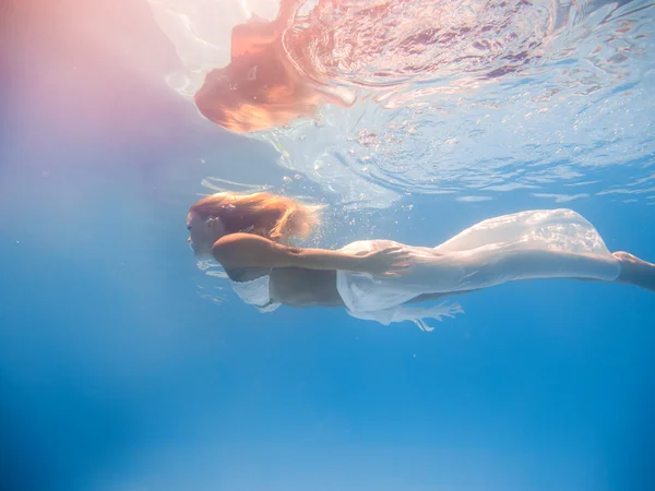 水中で泳ぐ若い女性は — ストック写真