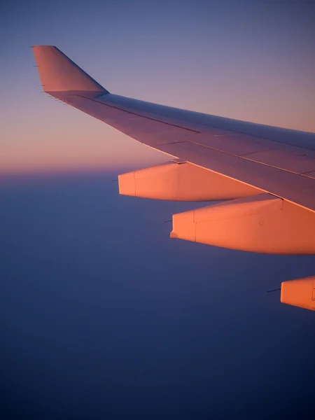 Ala do avião iluminada pelo pôr do sol — Fotografia de Stock