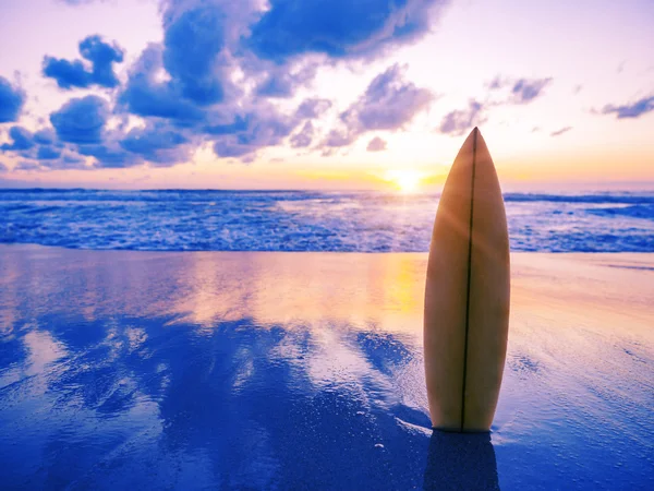 Tabla de surf en la playa al atardecer — Foto de Stock