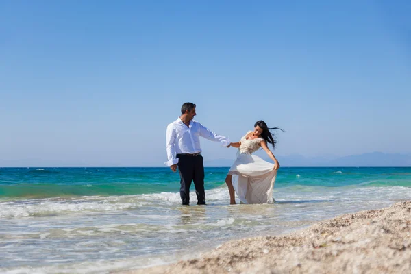 Nevěsta a ženich, společně ve slunečních paprscích na krásné tropické — Stock fotografie