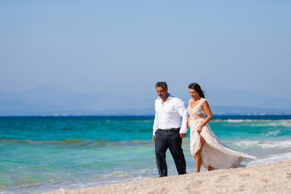 Bride and groom, together in sunshine on a beautiful tropical be — Stock Photo, Image