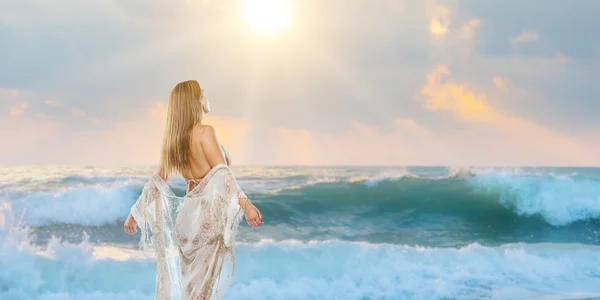 Kvinna elegant promenerar på stranden — Stockfoto