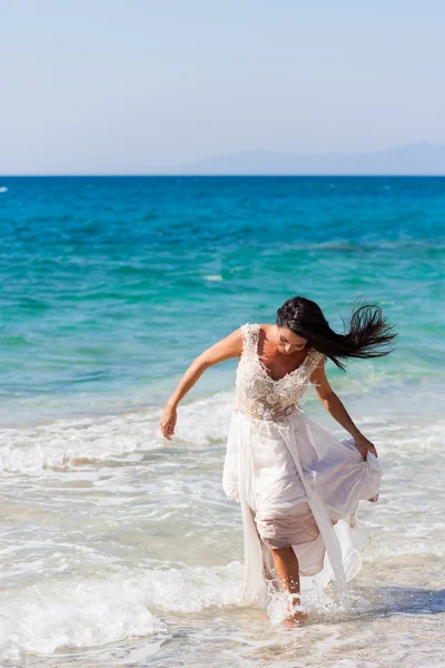Bruid in haar witte jurk op het strand — Stockfoto
