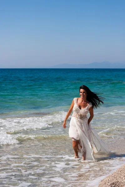 Novia en su vestido blanco como la nieve en la playa — Foto de Stock