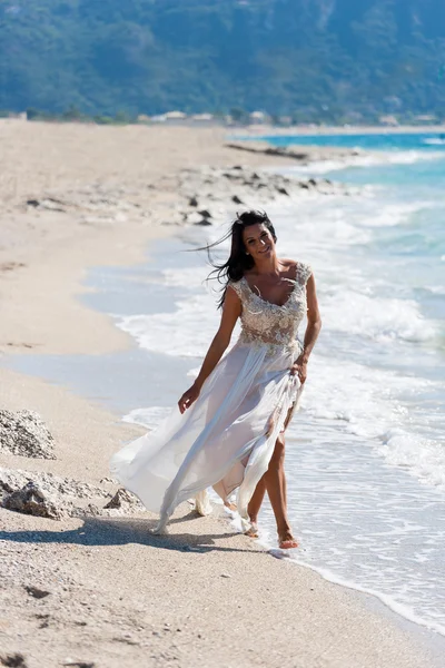 Noiva em seu vestido branco de neve na praia — Fotografia de Stock