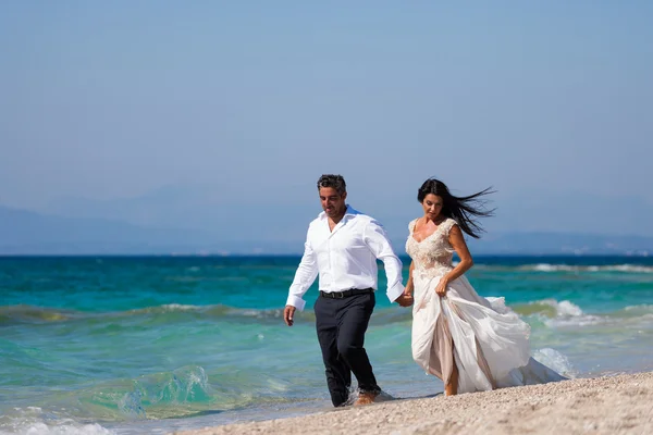 Bride and groom at tropical beach — Stock Photo, Image