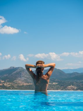 Beyaz bikinili seksi kadın sonsuzluk havuzu relax