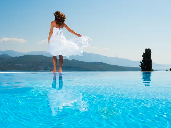 Bruden står på kanten på infinity-poolen — Stockfoto