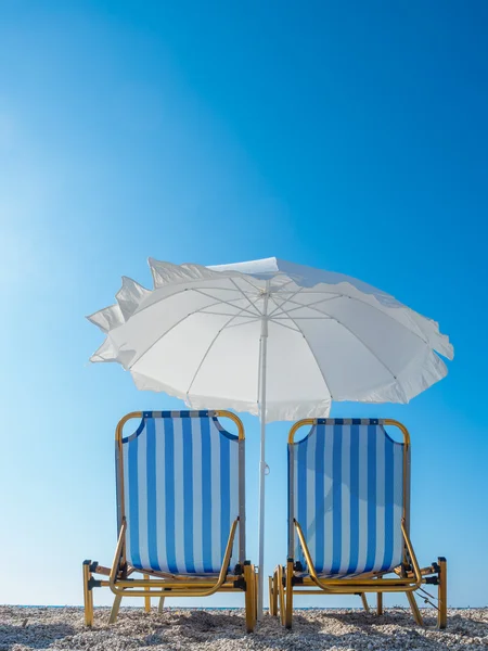 Bed en paraplu op het strand — Stockfoto