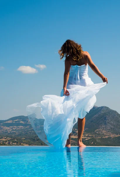 Sposa in piedi sul bordo della piscina a sfioro — Foto Stock