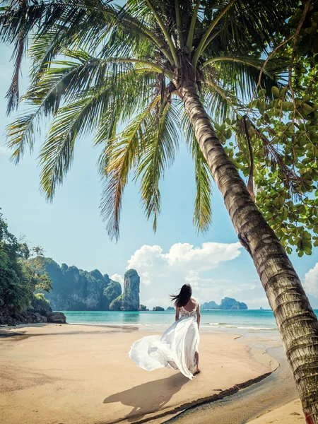 Жінка в елегантній весільній сукні, що йде на маяку — стокове фото